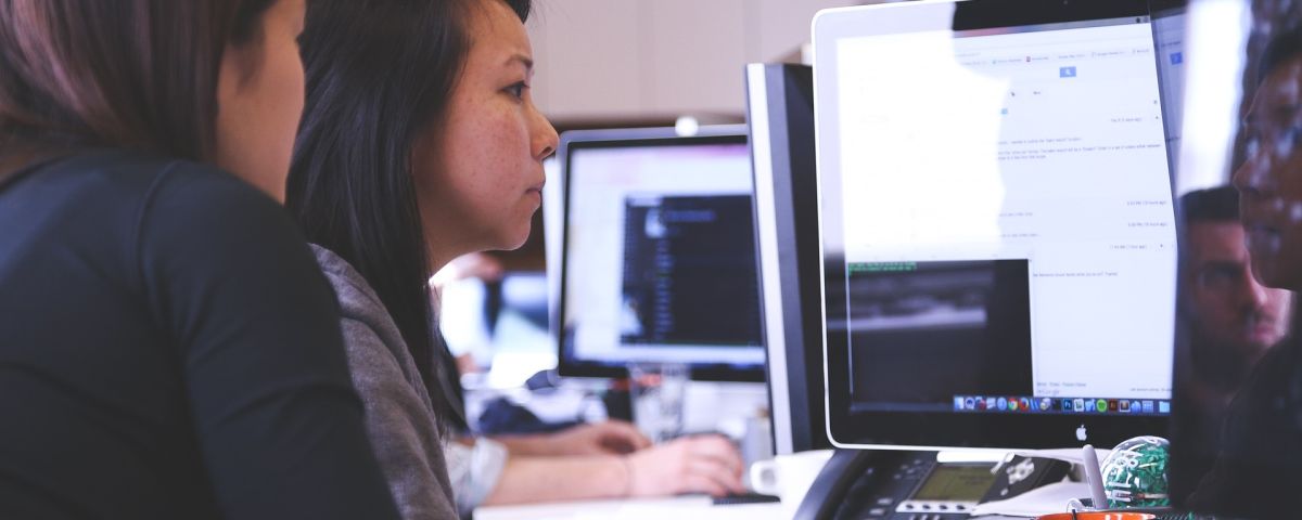 Zwei Frauen arbeiten gemeinsam am Bildschirm als Symbol für innovatives IT-System - TOM SPIKE