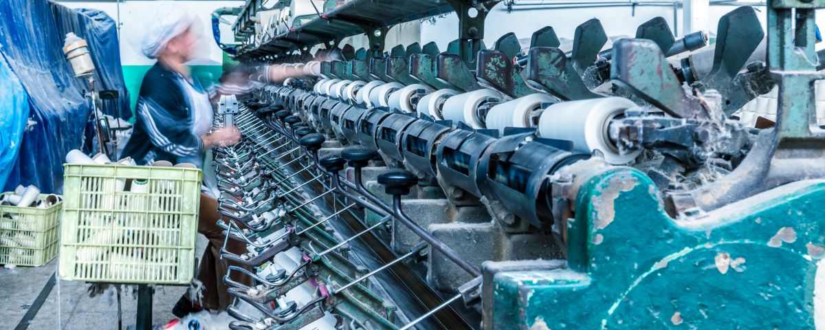 Blaue Textilmaschine mit Stoffspindeln als Symbol für Business Model Innovation in der Textilindustrie - TOM SPIKE