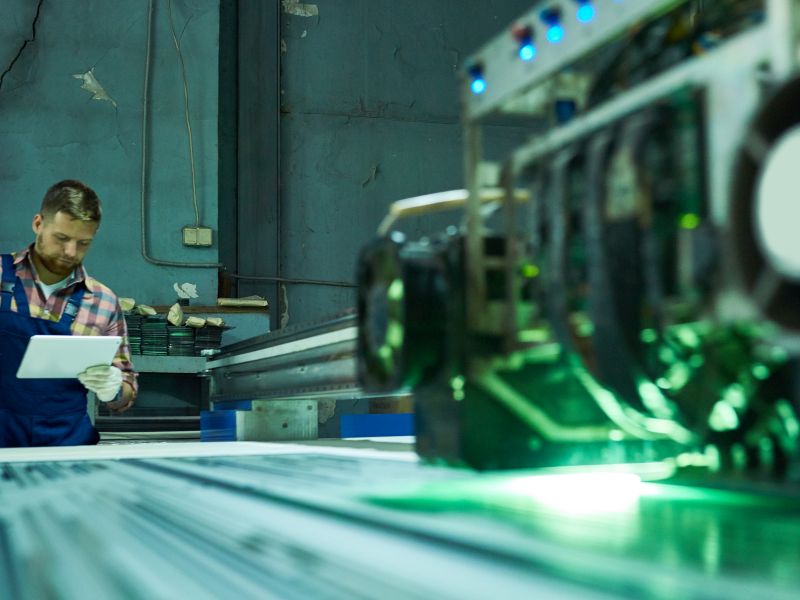 Worker at production machine as a symbol for product innovation - TOM SPIKE