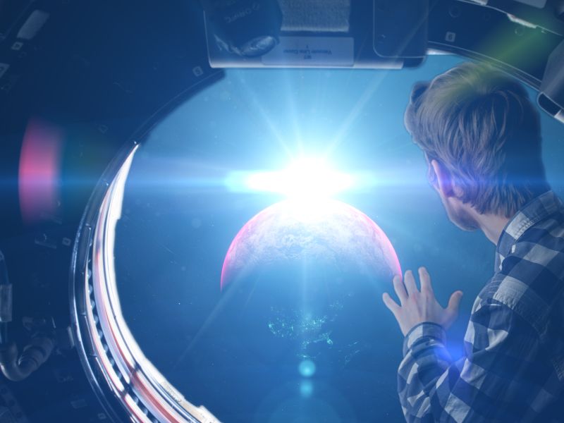 Young man looking out of space ship window seeing Earth as a symbol for Product Innovation - TOM SPIKE