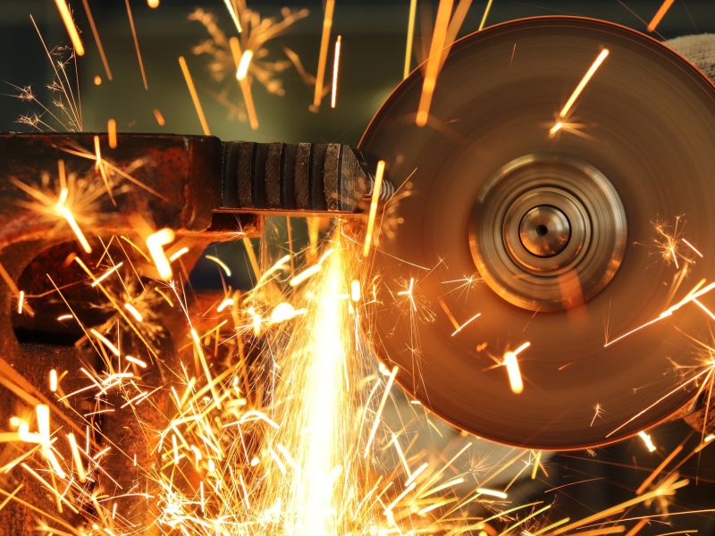 Cutting tool cutting metal with glowing sparks as a symbol for product innovation - TOM SPIKE