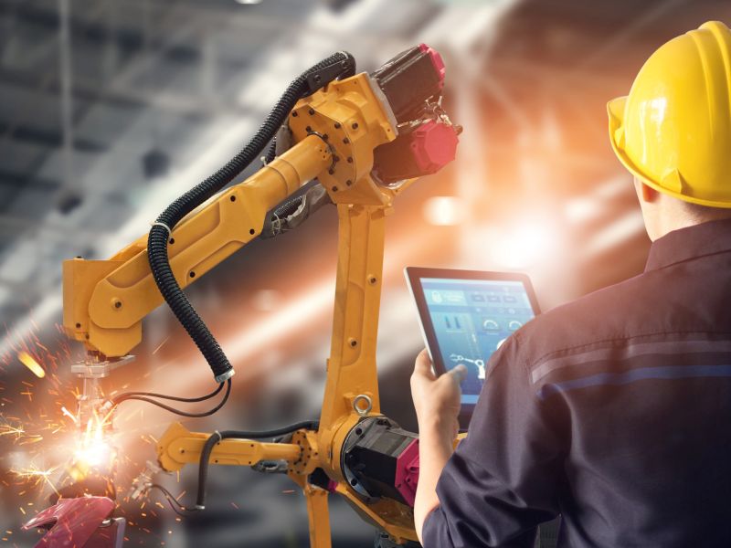Technician controls robot with tablet as a symbol for business model innovation - TOM SPIKE