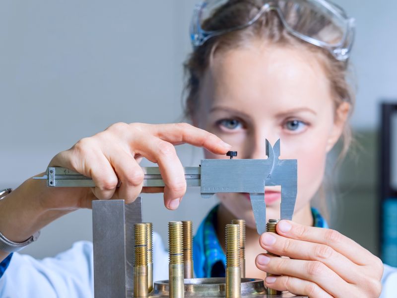 Ingenieurin analysiert Schrauben im Labor als Sinnbild für Produktideen durch Analyse - TOM SPIKE