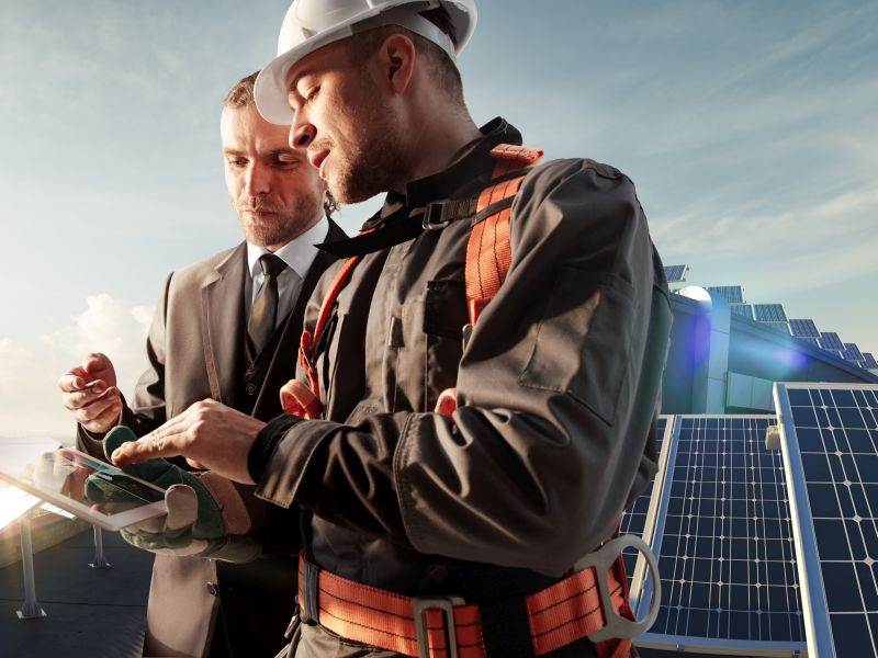 Technicians and managers on the solar roof with tablet as a symbol for digital service accounting - TOM SPIKE