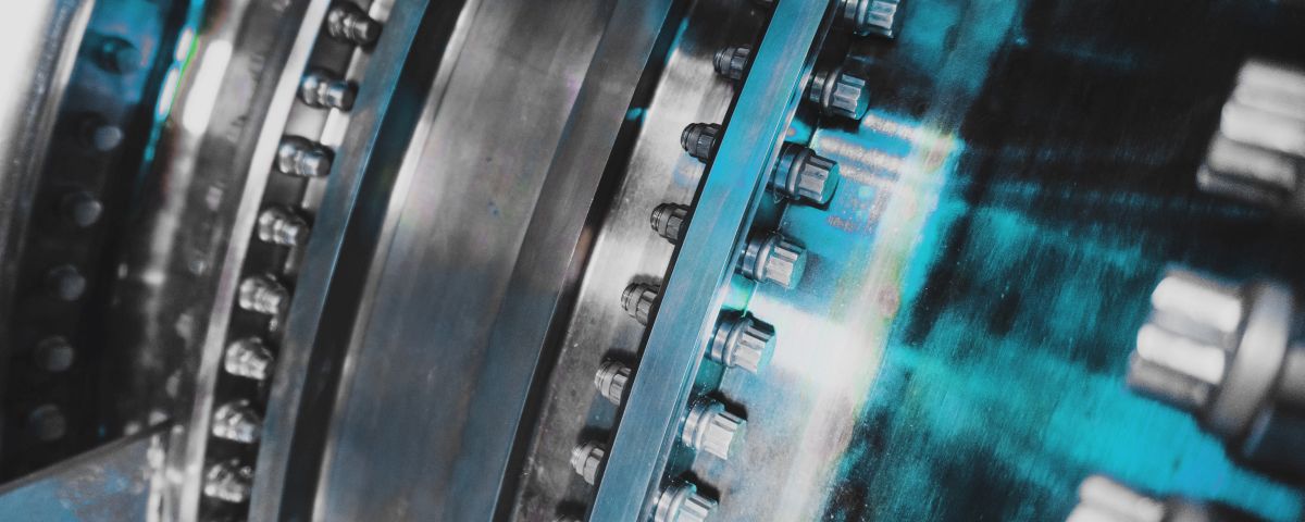 A detailed view of the gas turbine engine for generating electricity, shows the bolt connection design and the pipe laying outside. Verschraubung an Flugzeugturbine - TOM SPIKE Structured innovation