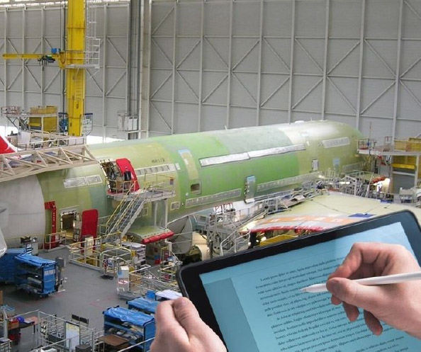 Hände notieren Informationen auf einem Tablet vor der Montage und Lackierung eines Passagierflugzeugs