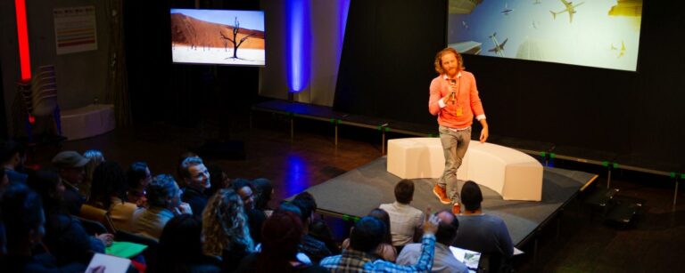 junger, hipper Moderator auf der Bühne als Symbol für Storytelling und Innovationskommunikation - TOM SPIKE