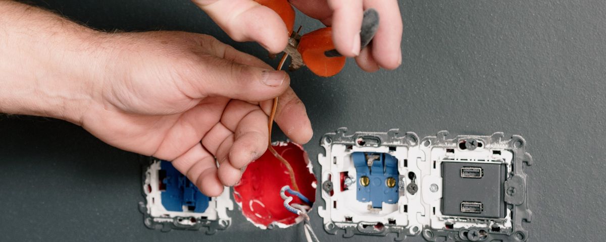 Elektrikerhand verkabelt Schalterleiste als Symbol für Problemhypothese und Validierung - TOM SPIKE Structured innovation, Innovationsberatung