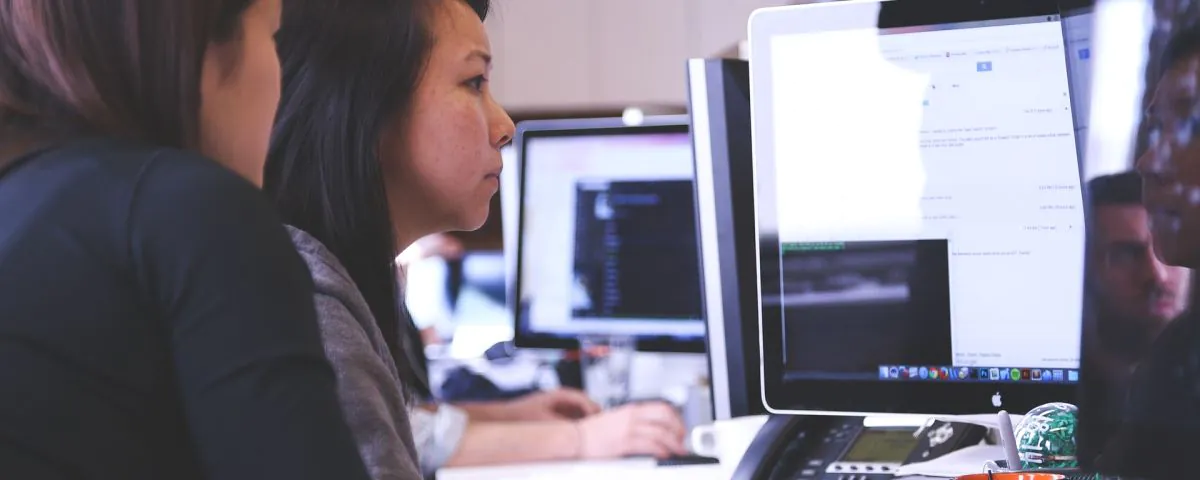 Zwei Frauen arbeiten gemeinsam am Bildschirm als Symbol für innovatives IT-System - TOM SPIKE