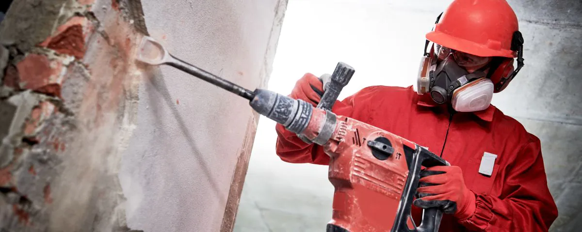 Bauarbeiter mit Helm und Bohrhammer als Symbol für Geschäftsmodellinnovation in der Bauindustrie