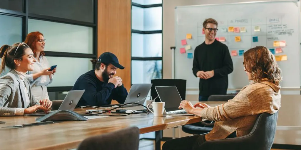 Kreatives Innovationsteam hat Spaß bei der Arbeit im Meetingraum mit Whiteboard und Sticky Notes - TOM SPIKE